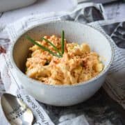 Close up of egg salad with paprika and chives in a bowl.