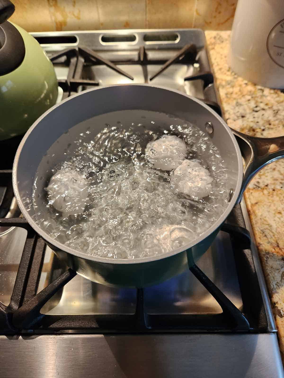 Eggs in a pot of boiling water.