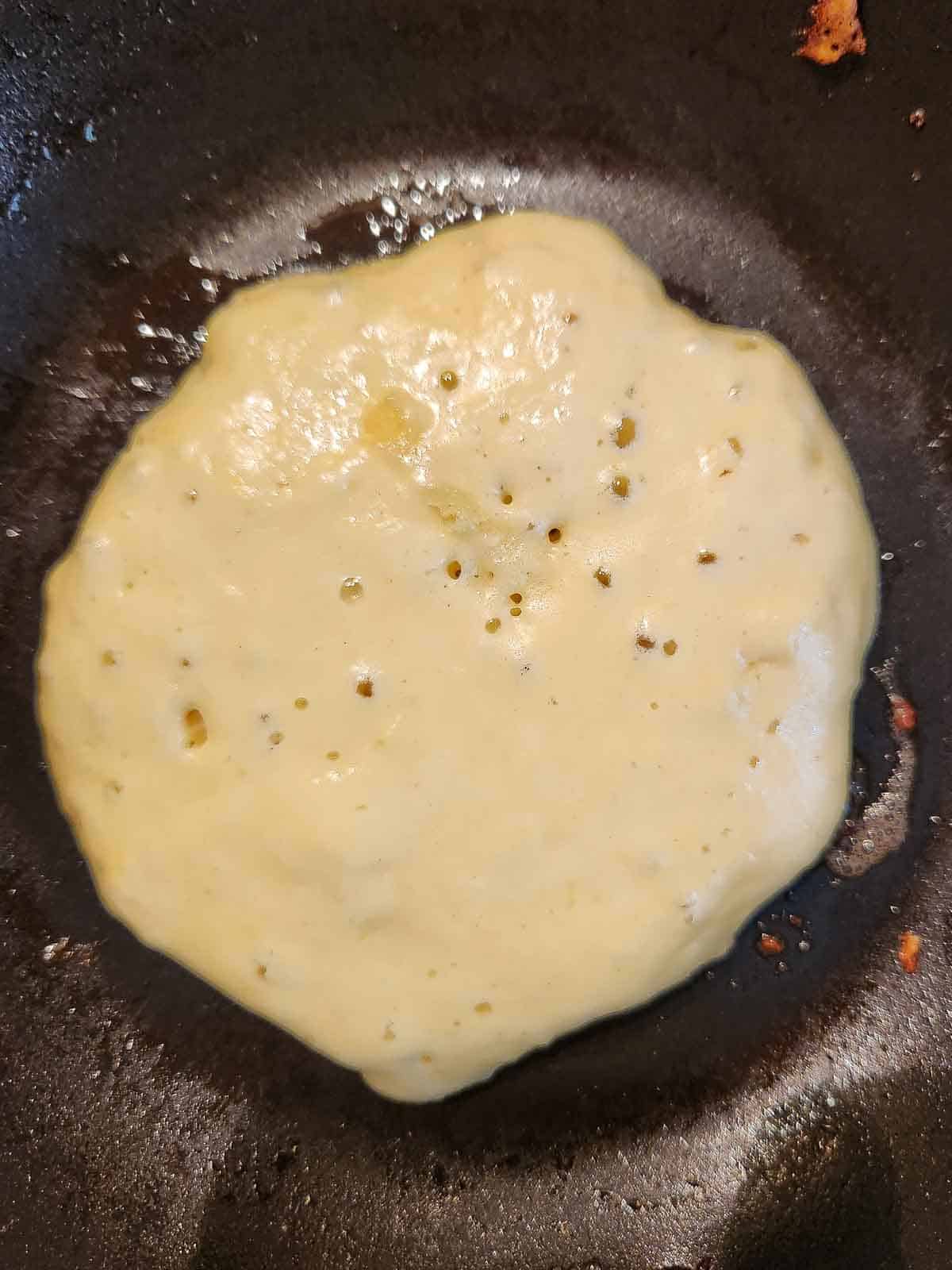 Lemon mascarpone pancake batter in a skillet being cooked.