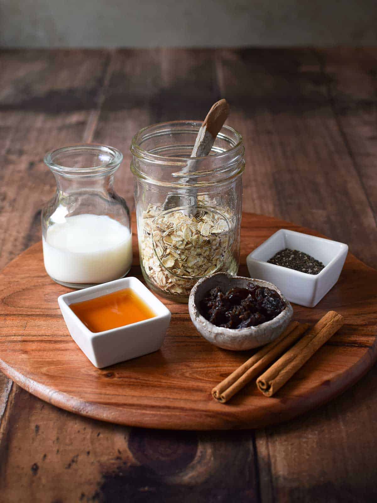 Ingredients for overnight oats on a wooden serving board.