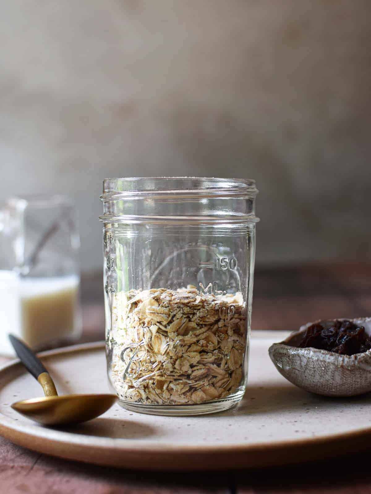 Oats in a jar on a brown plate.