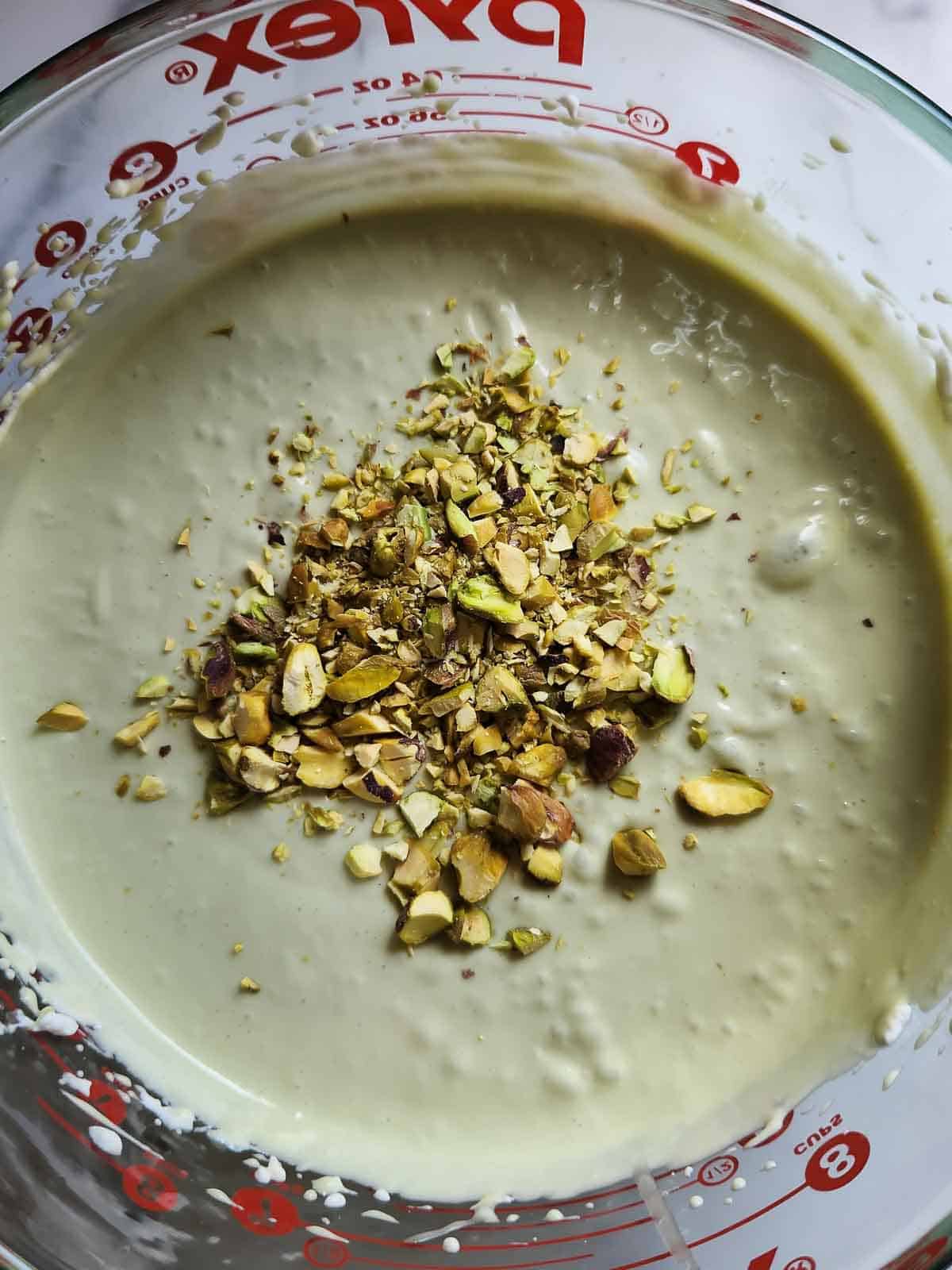 Mixed pistachio ice cream base for home made ice cream in a bowl.
