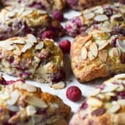 Close-up of raspberry almond scones on parchment paper.