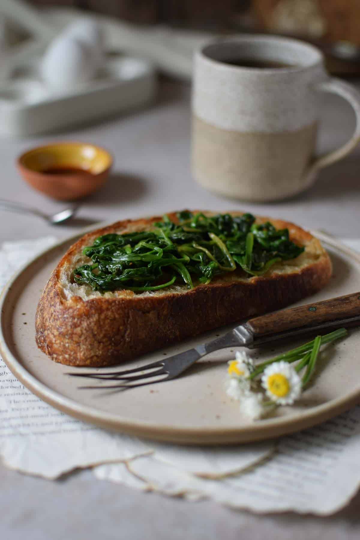 Spinach on toast on a brown plate.