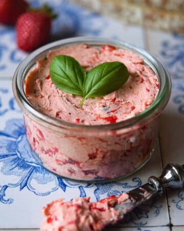 Close-up of whipped strawberry basil butter in a glass jar.