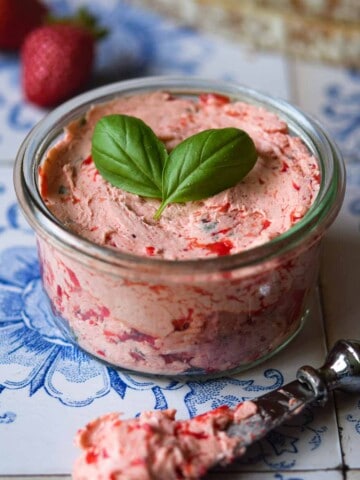 Close-up of whipped strawberry basil butter in a glass jar.