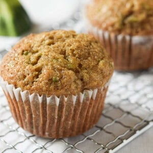 Close up of a zucchini muffin on a metal rack.