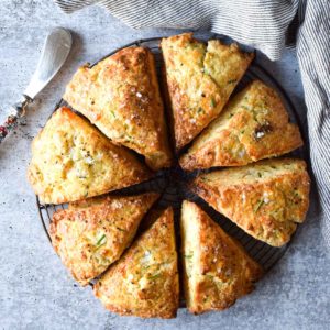 Overhead view of smoked gouda and chive scones cut in eight triangles on a concrete gray background