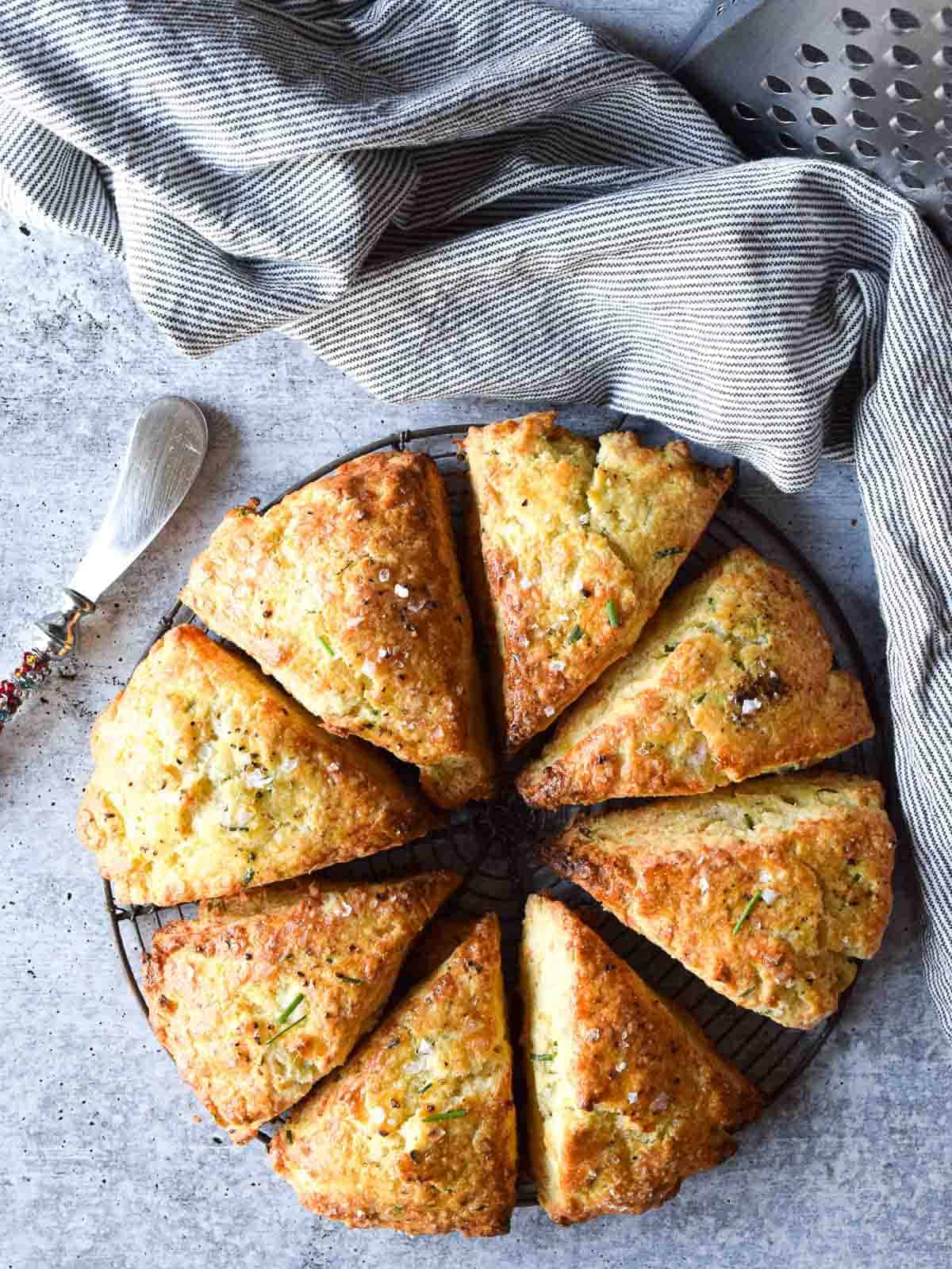 Overhead view of smoked gouda and chive scones cut in eight triangles on a concrete gray background