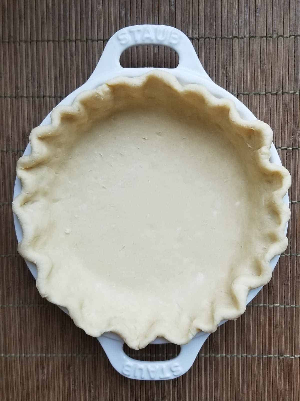 Unbaked pie dough crimped in a pie plate