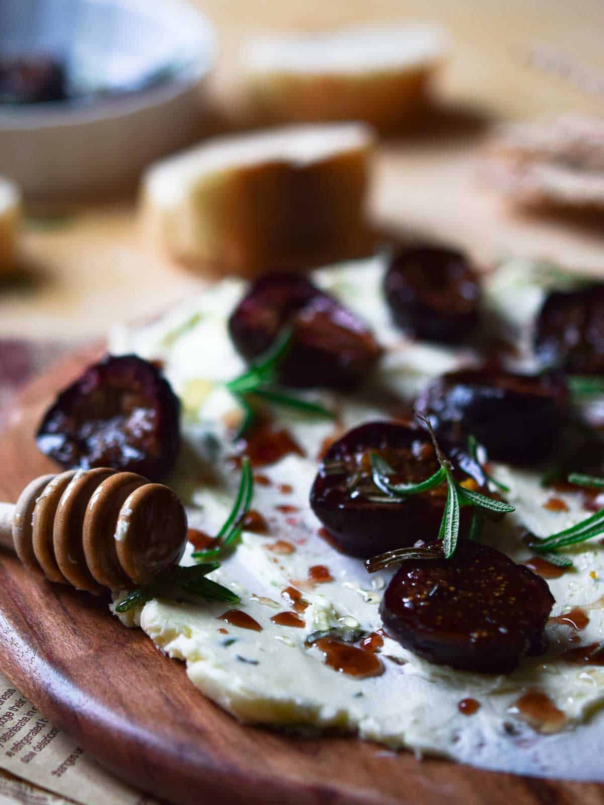 Close up view of roasted figs on a serving board with butter.