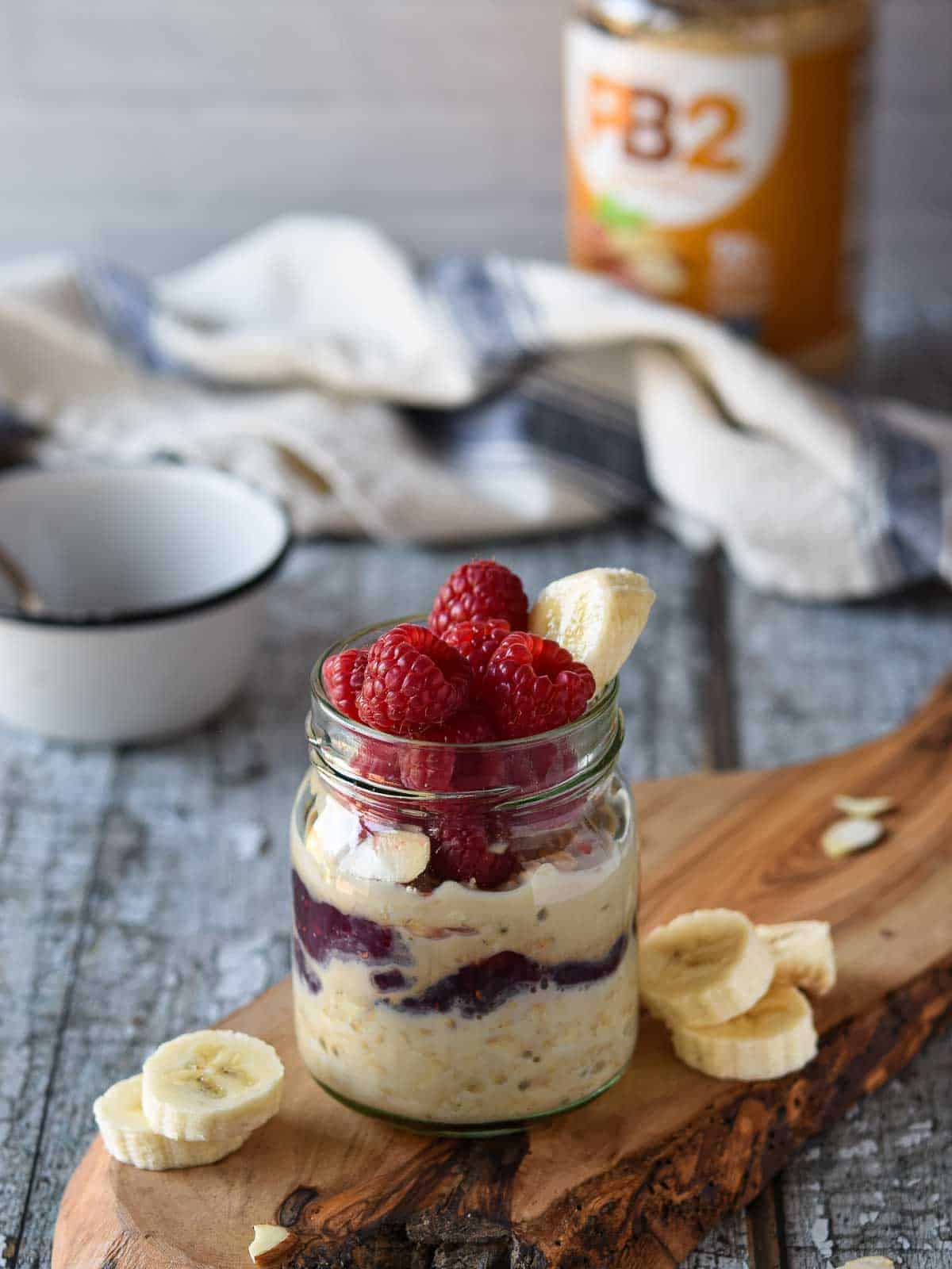 Peanut butter overnight oats in a jar with raspberries and bananas.