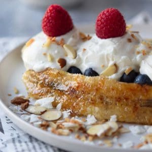 Breakfast banana split with yogurt with fresh fruit and nuts.