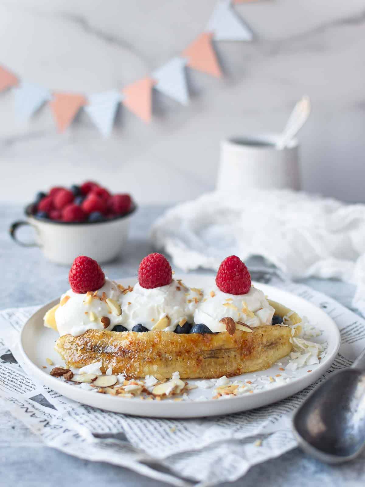 Breakfast banana split with yogurt with fresh fruit and nuts.