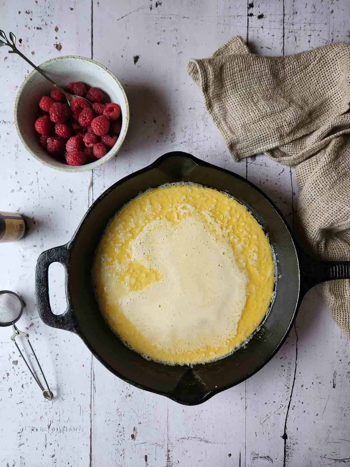Dutch baby batter poured into a hot cast iron skillet.
