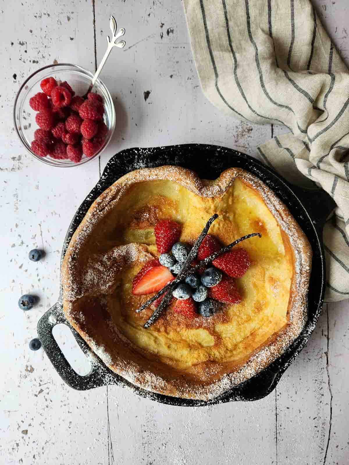 Overhead of fruit toppings in the center of a Dutch baby.