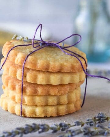 Lemon lavender shortbread cookies stacked and tied with a purple ribbon.