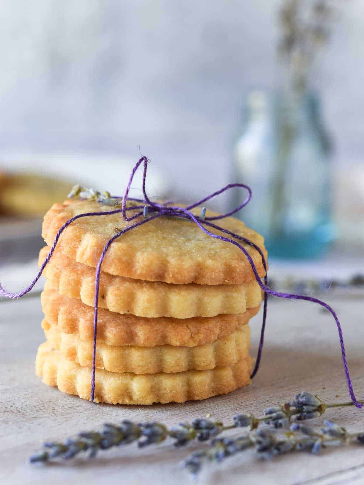 Lemon lavender shortbread cookies stacked and tied with a purple ribbon.