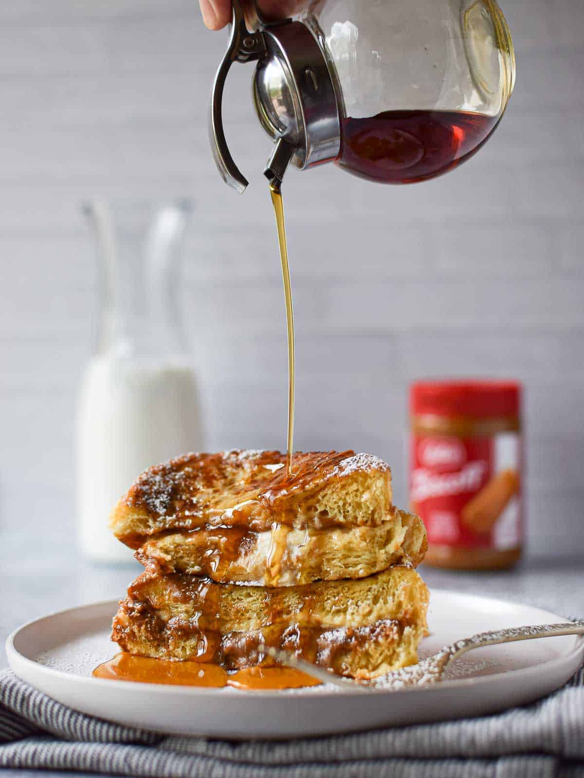 Syrup being poured over Biscoff stuffed French toast.