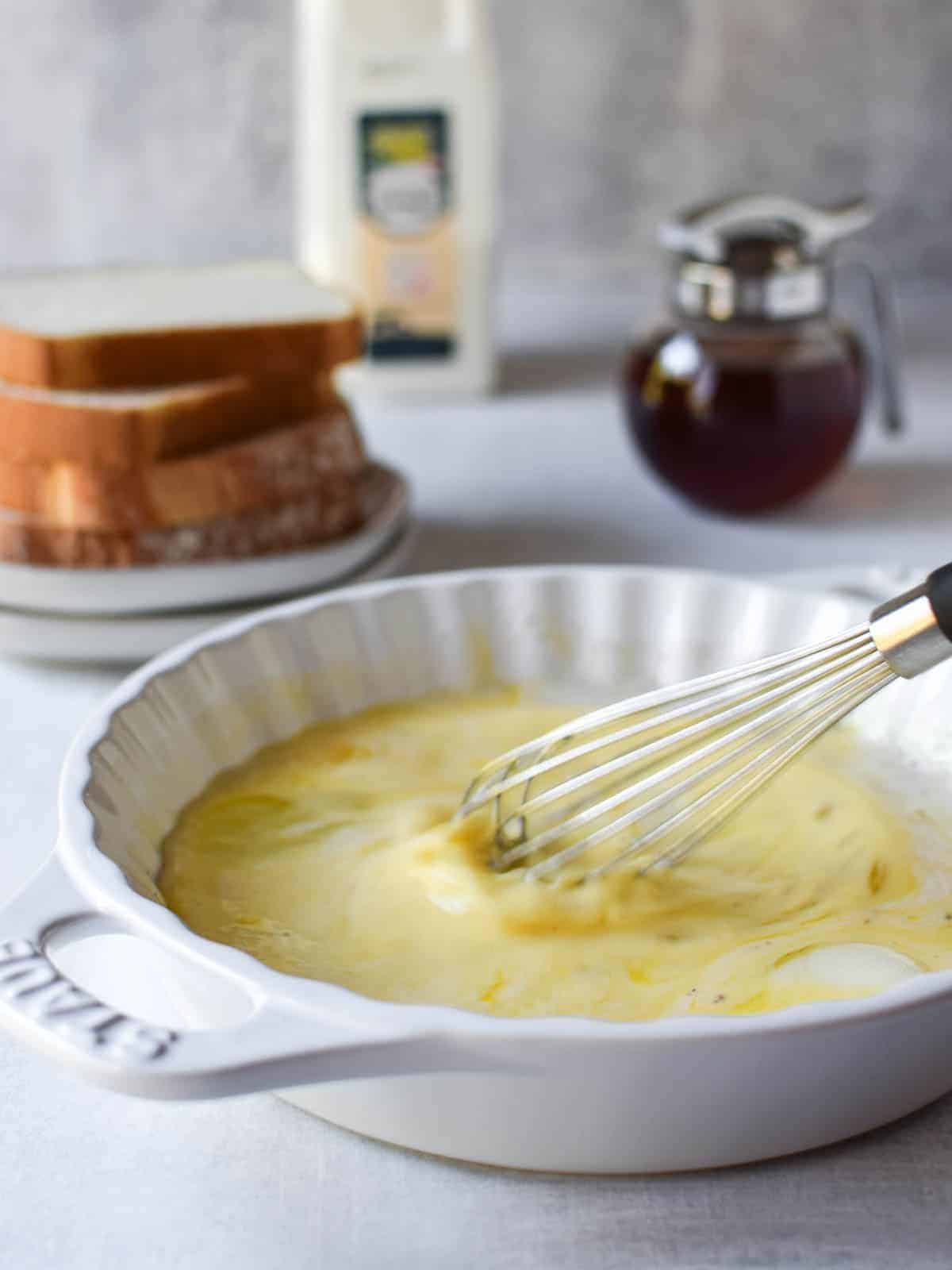 Mixed custard for French toast in a white shallow bowl.
