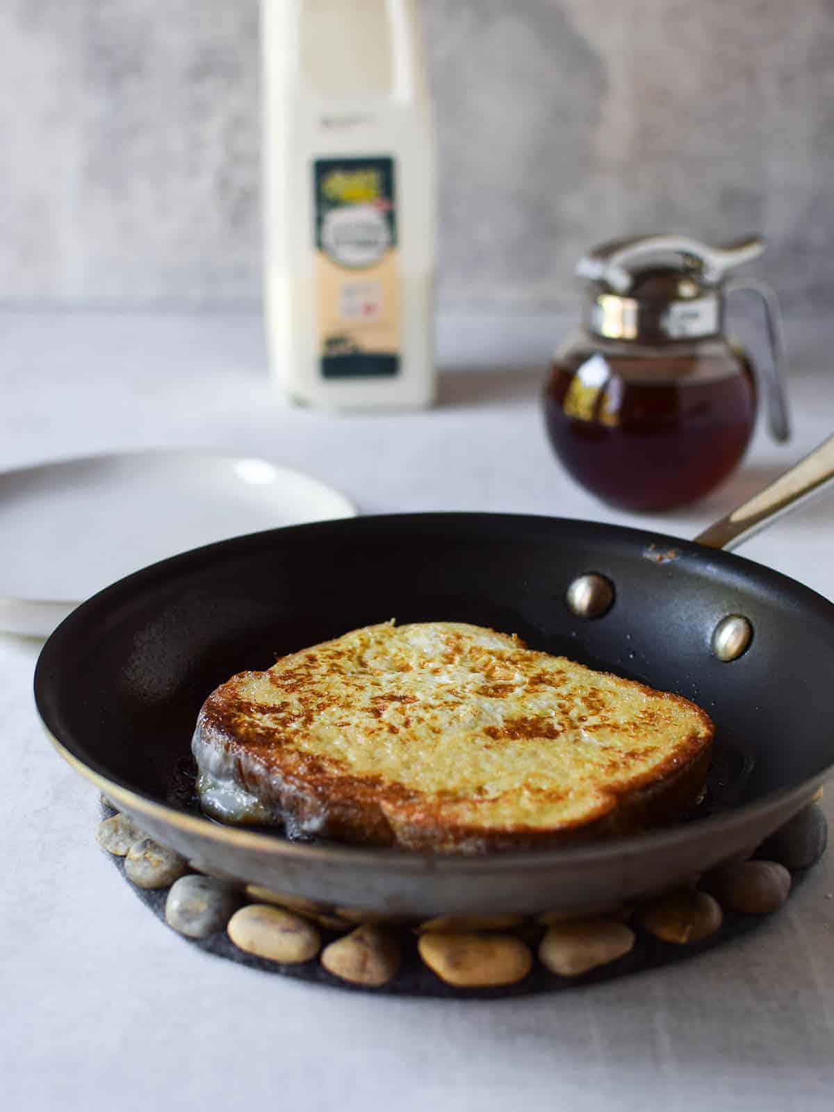 Golden brown cooked French toast in a frying pan.