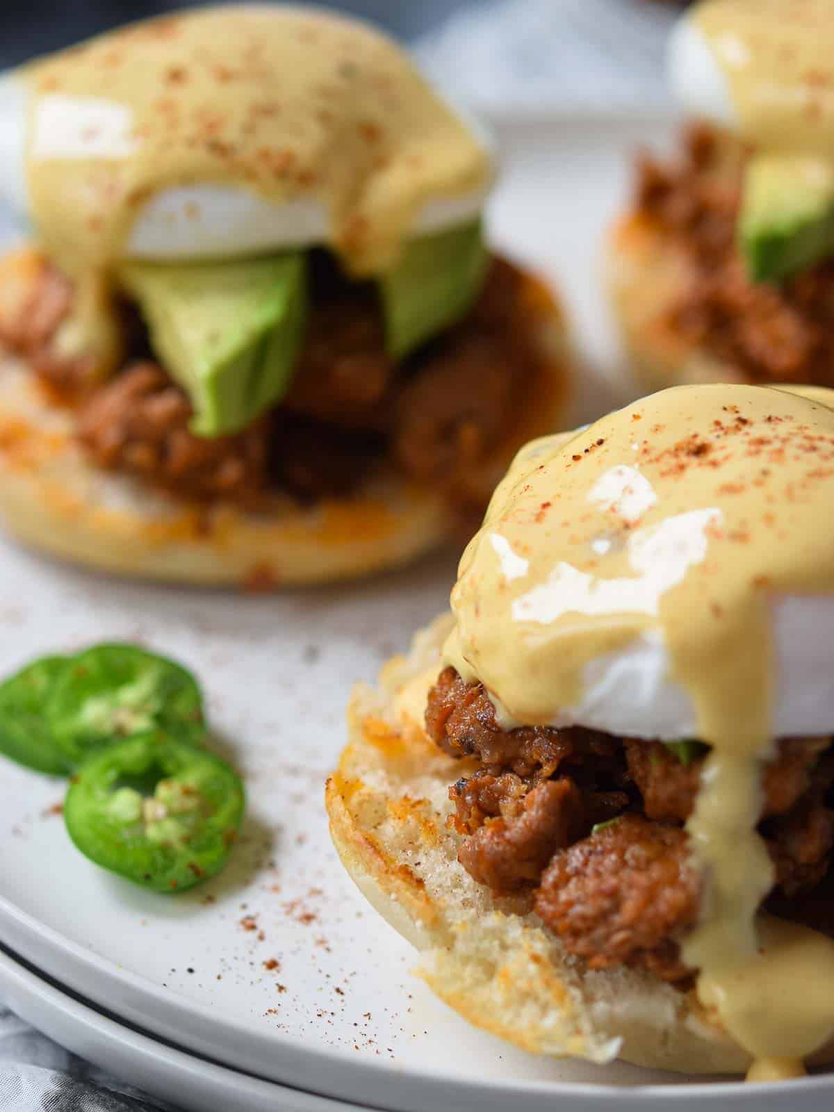 Close-up of Mexican eggs benedict with hollandaise sauce dripping down.