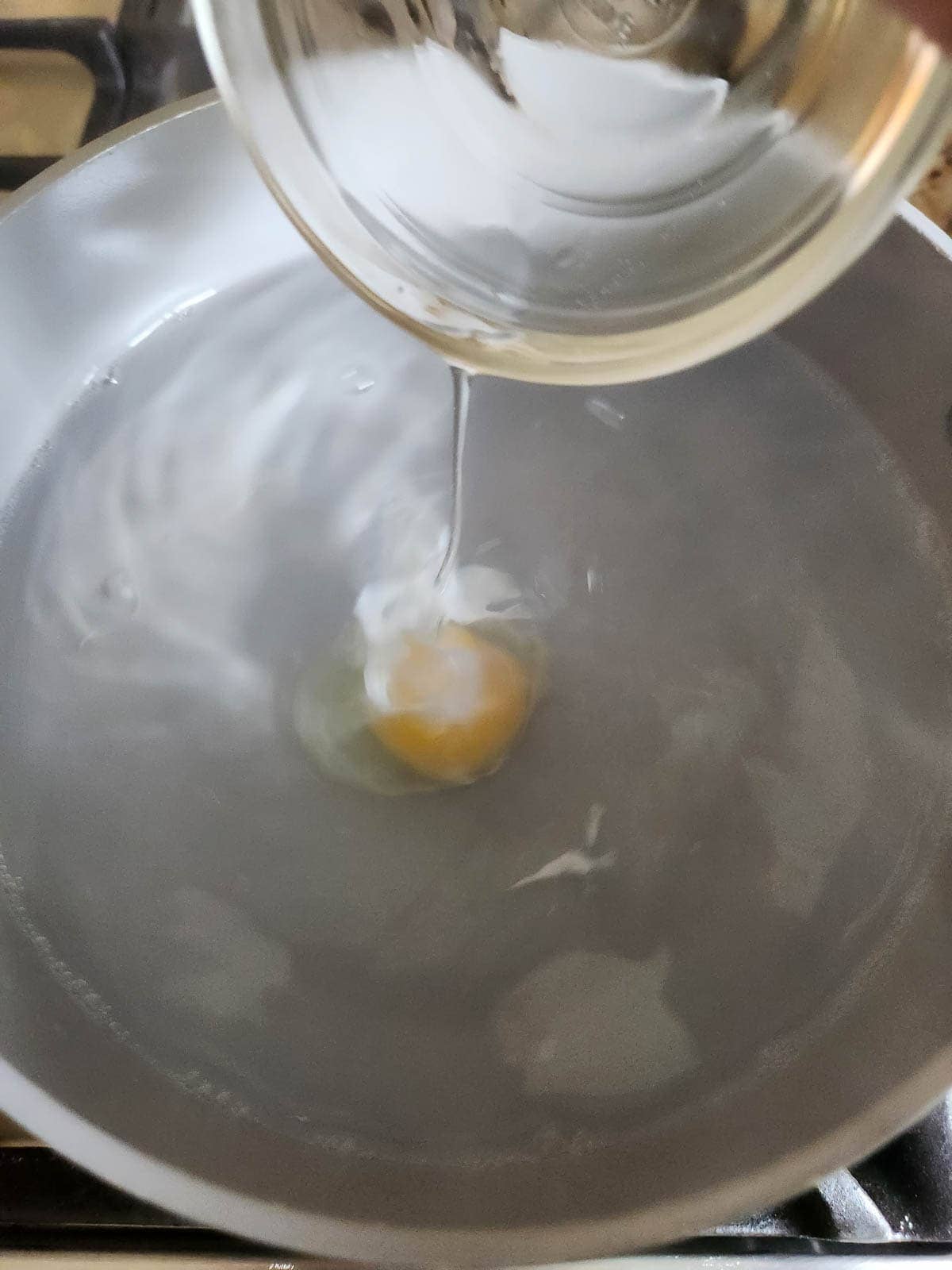 Egg dropped in boiling water for poached eggs.