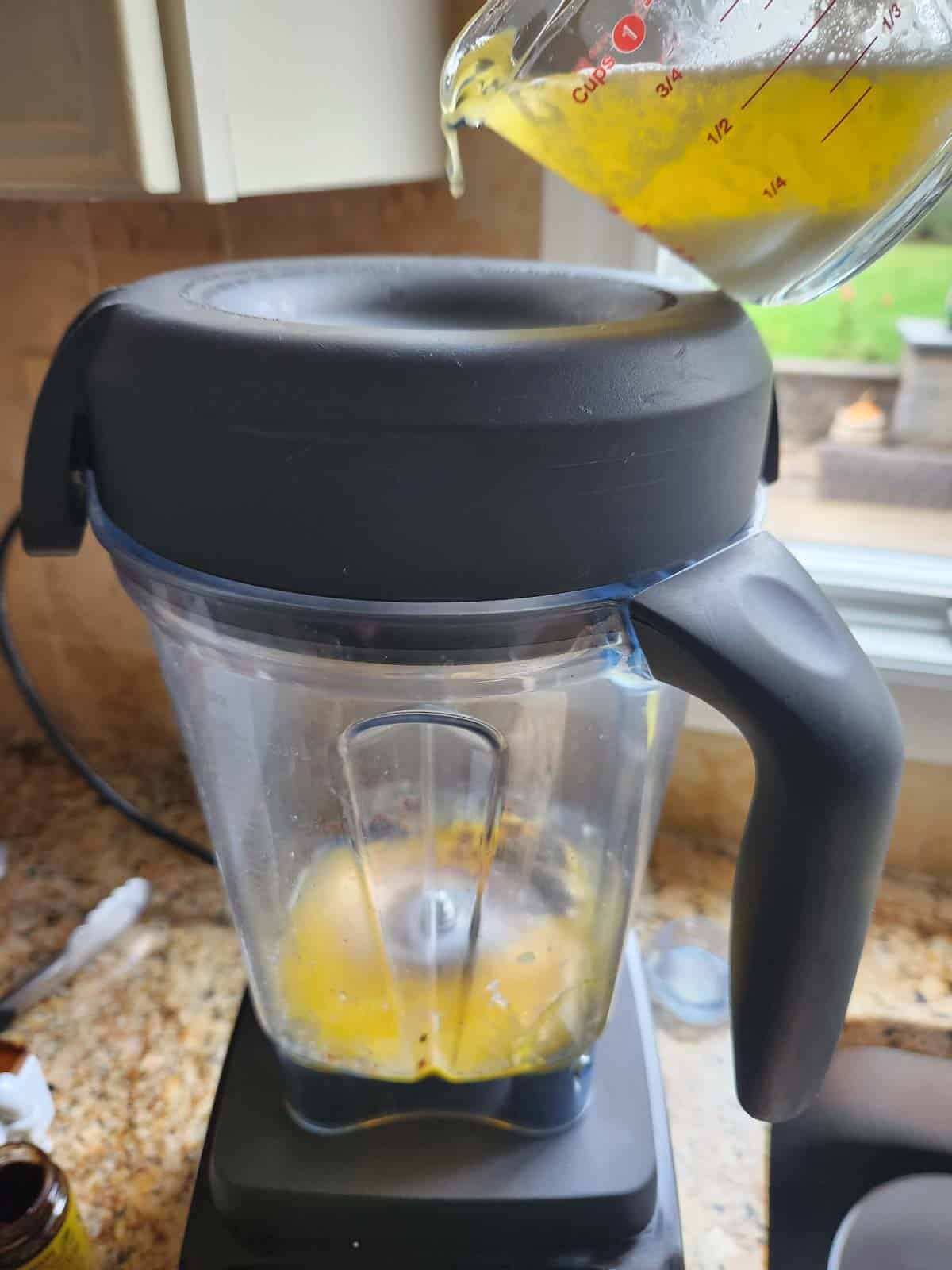 Butter is poured into a blender to make hollandaise sauce.