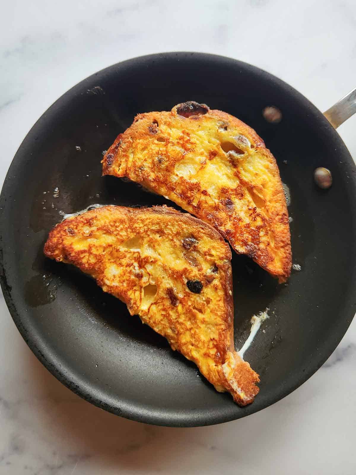 Cooked panettone French toast in a skillet.
