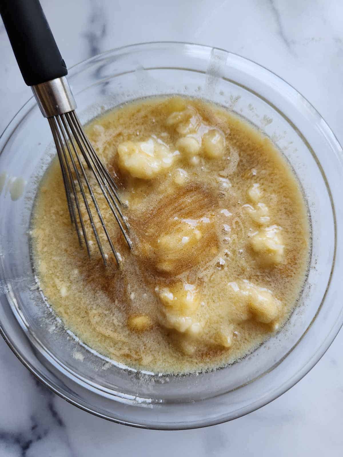 Wet ingredients in a bowl for banana muffins.