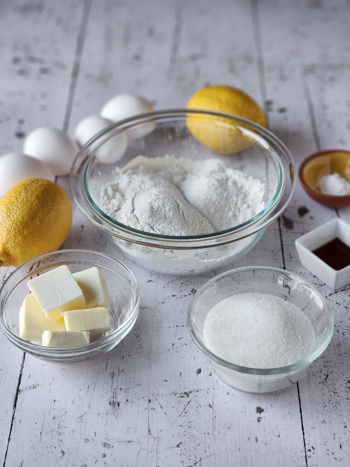 Ingredients for lemon pizzelles on white wood.