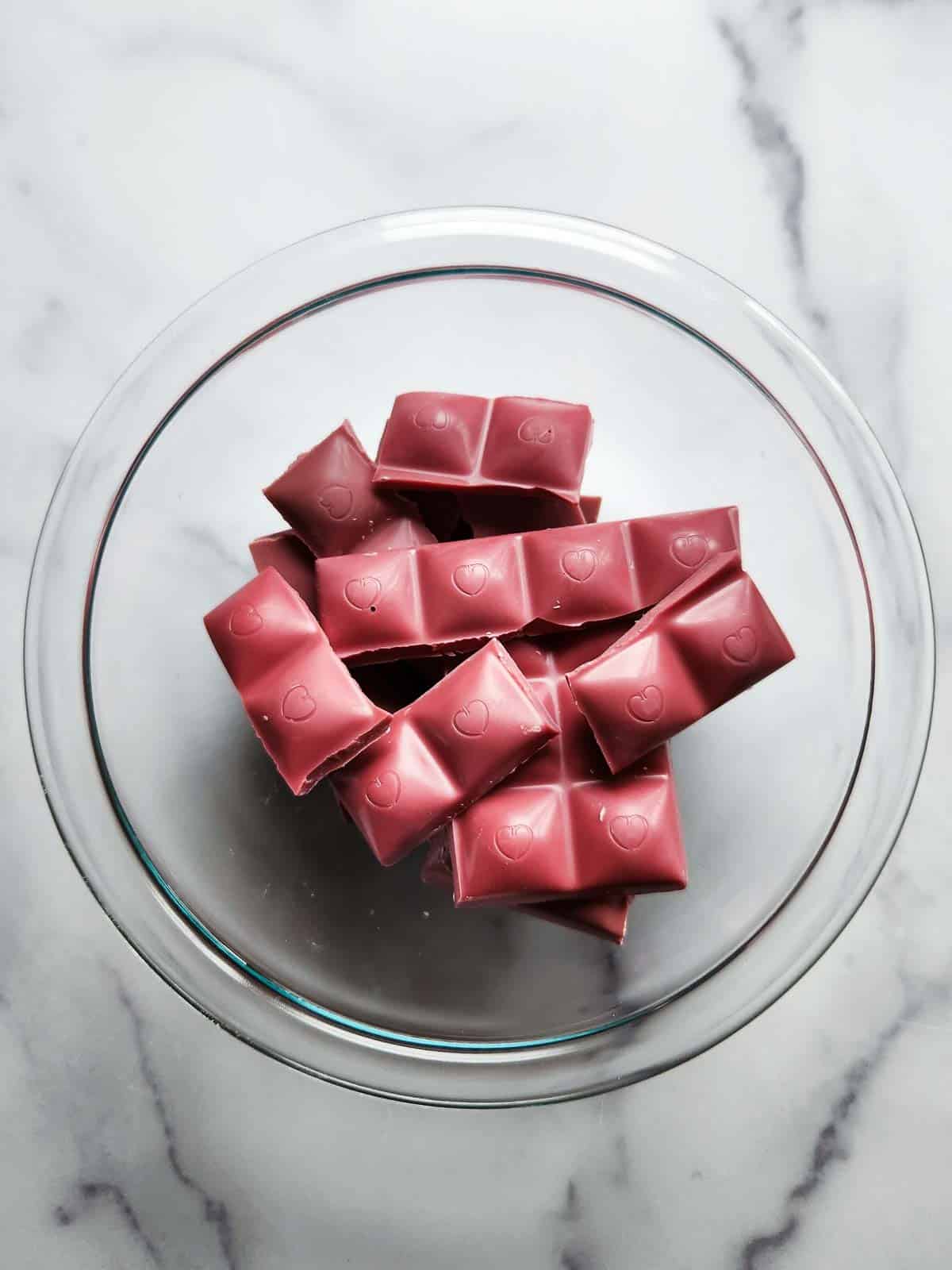 Chopped up pink chocolate in a bowl.