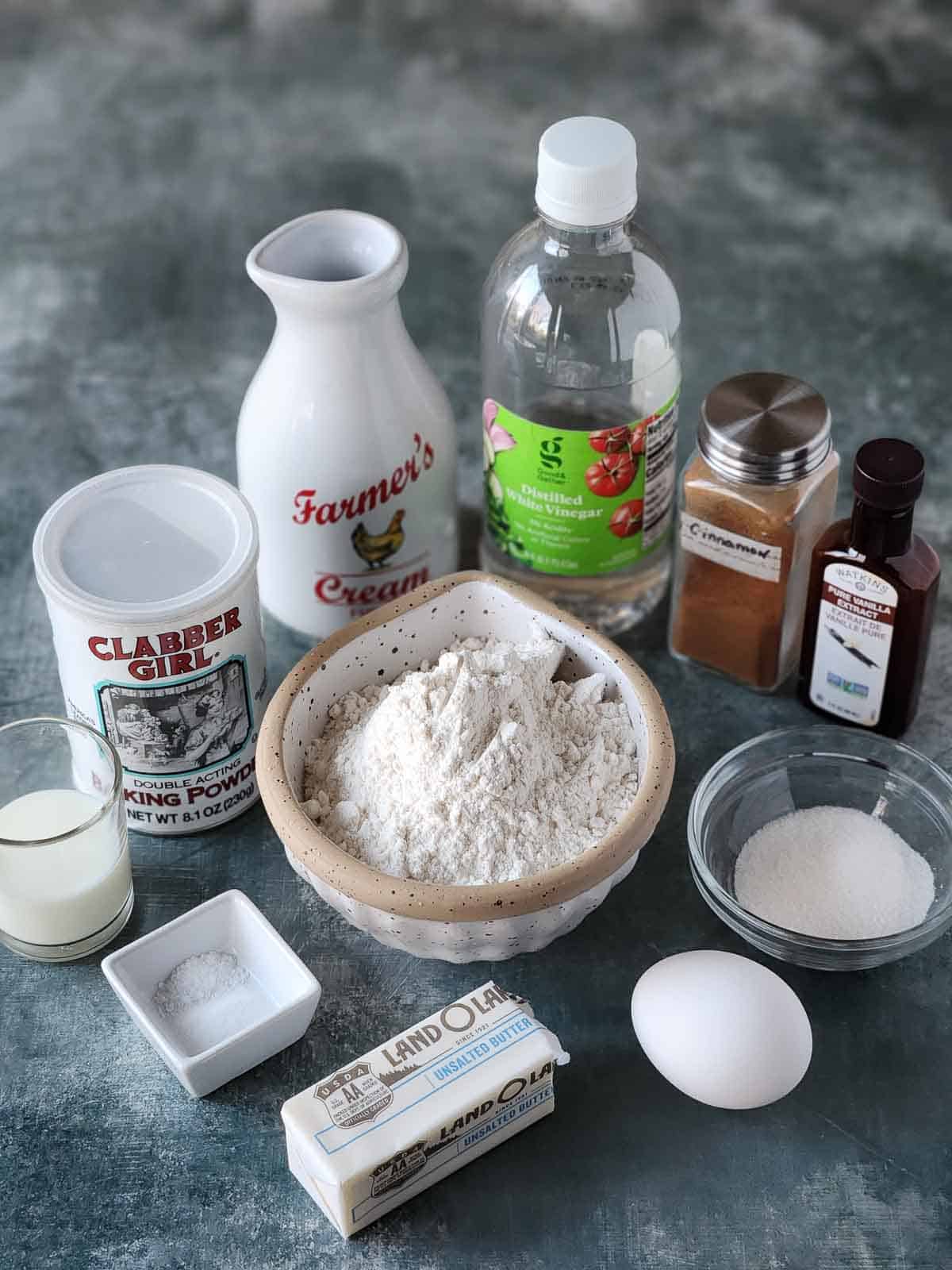 Ingredients for sweet cream pancakes on a grey surface.