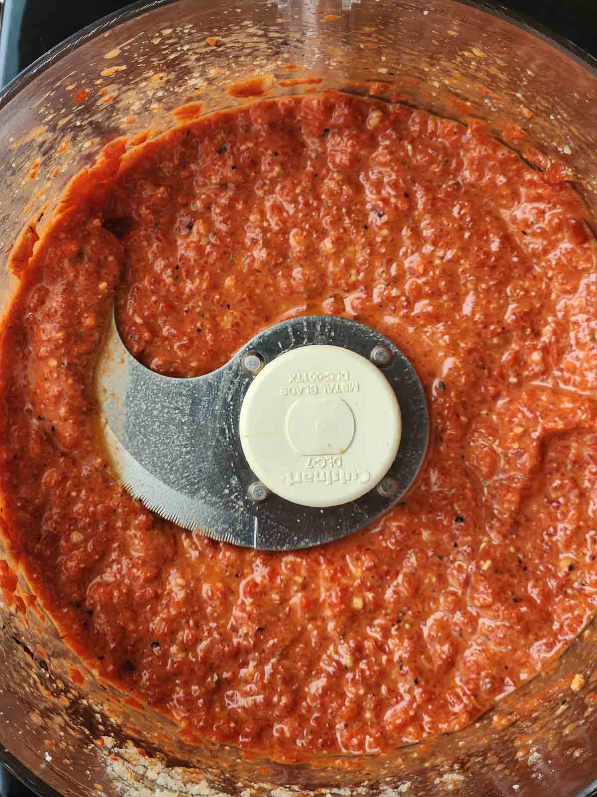 Overhead picture of red pepper pesto in a food processor.