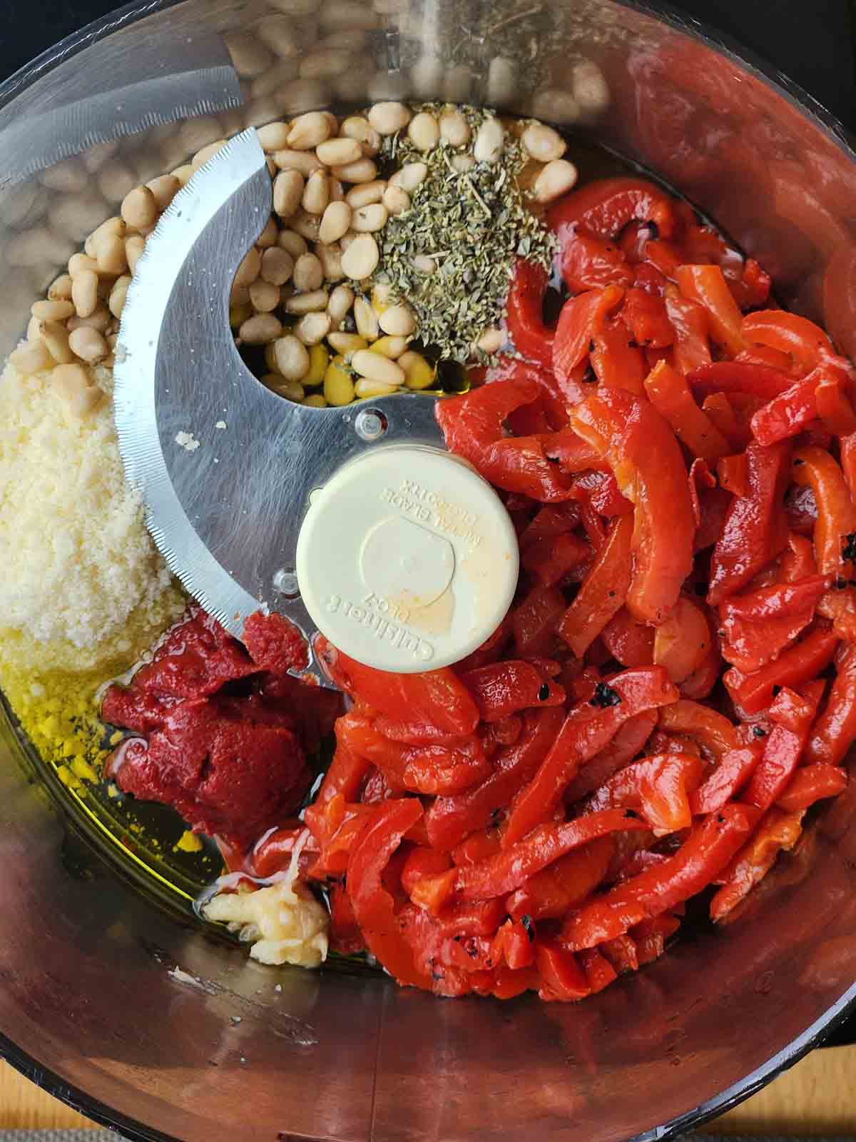 Ingredients for roasted red pepper pesto in a food processor.