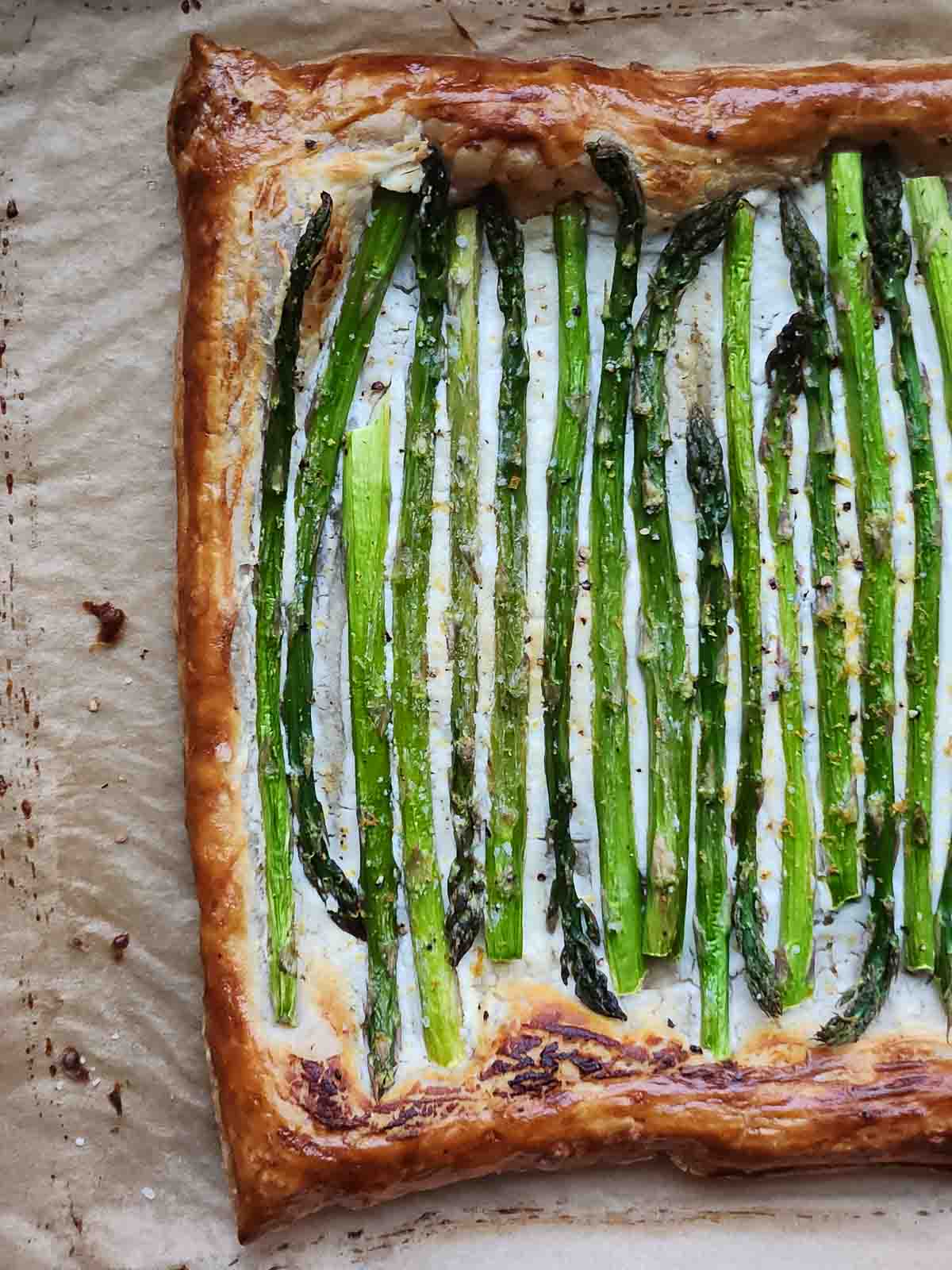 Asparagus and goat cheese puff pastry on parchment paper.