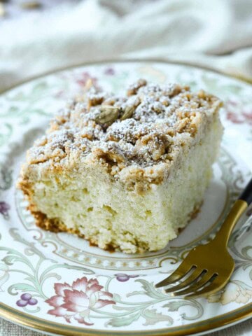 Close-up of coffee cake on a floured plate with a fork on the side.