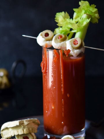 Bloody scary cocktail in a clear glass with cheese eyeballs.