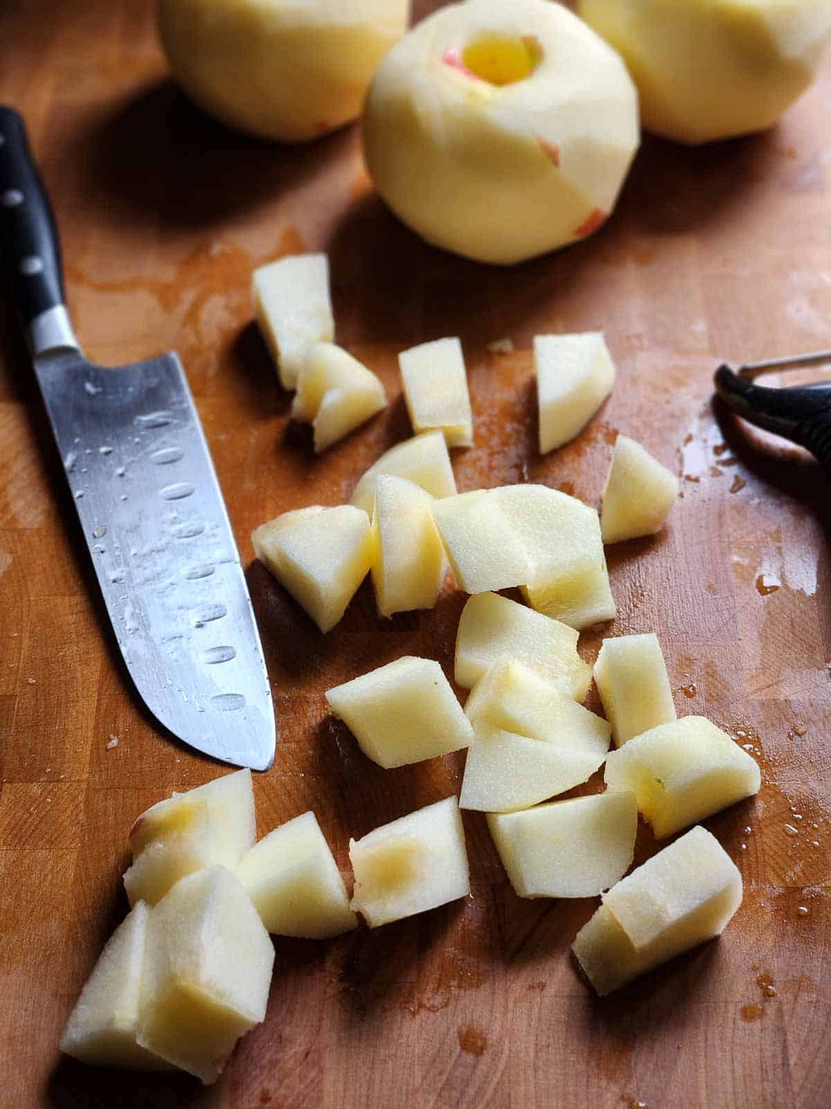 Chopped apples in cubes on a cutting board.