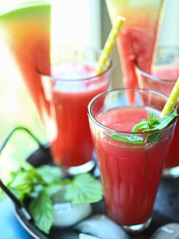 Three glasses of watermelon water by the window.