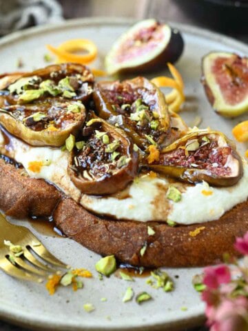 Close-up of fig toast on a beige plate.