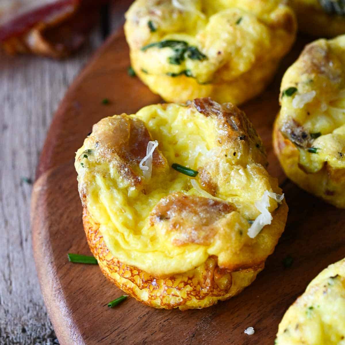 Bacon egg bites on a wood tray.