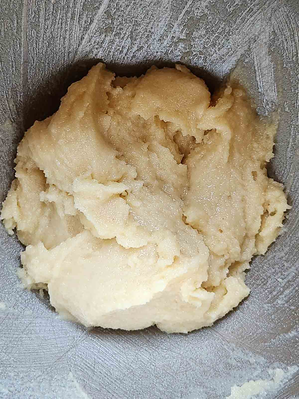 Batter for pignoli cookies in a metal bowl.