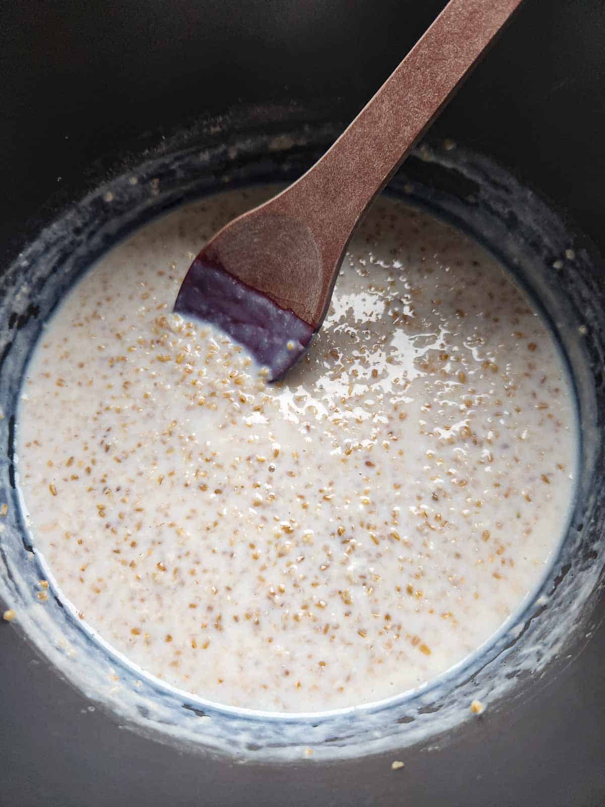 Overhead of oatmeal being stirred in pot.