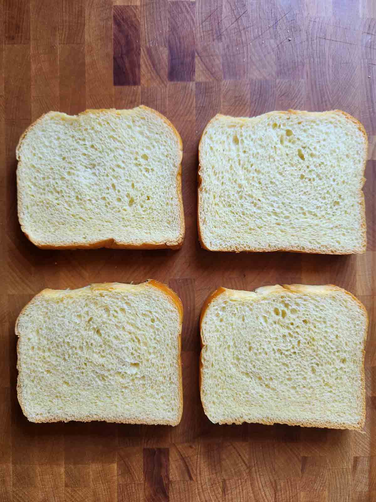 Four slices of bread on a cutting board.