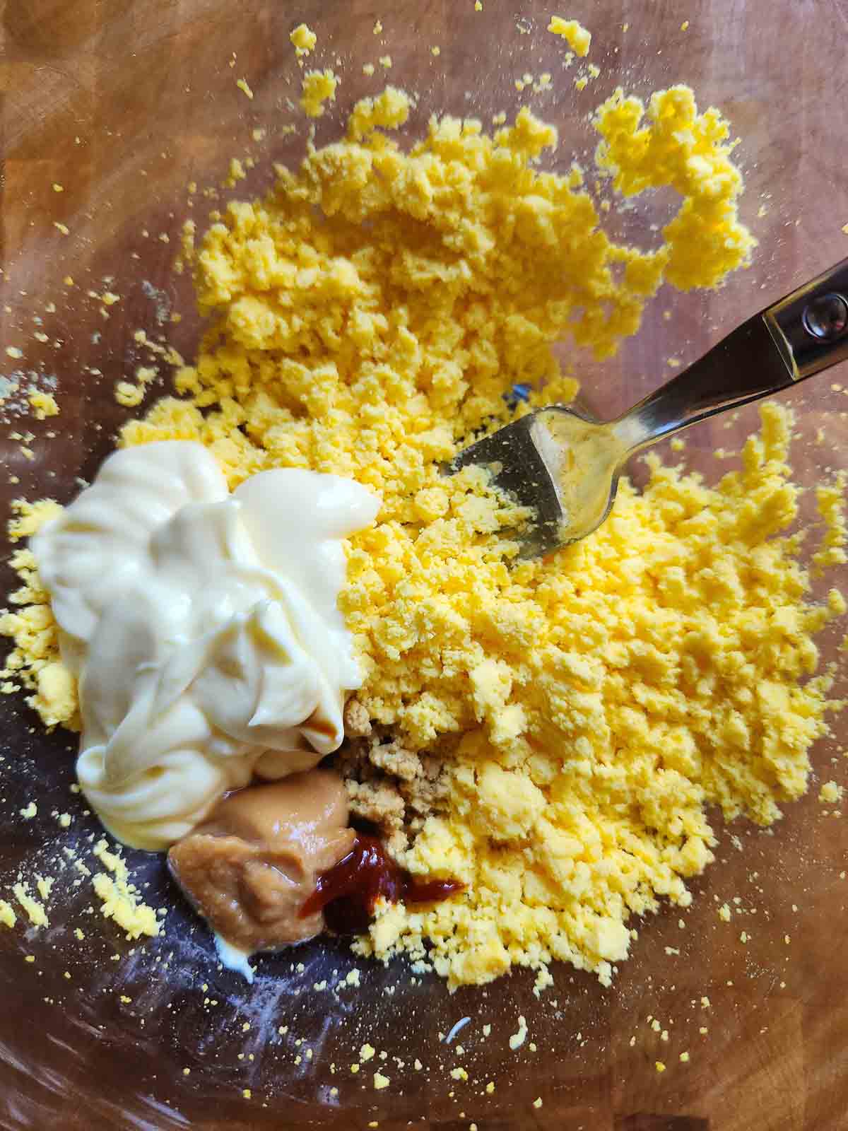 Filling for deviled eggs in a bowl with a fork.