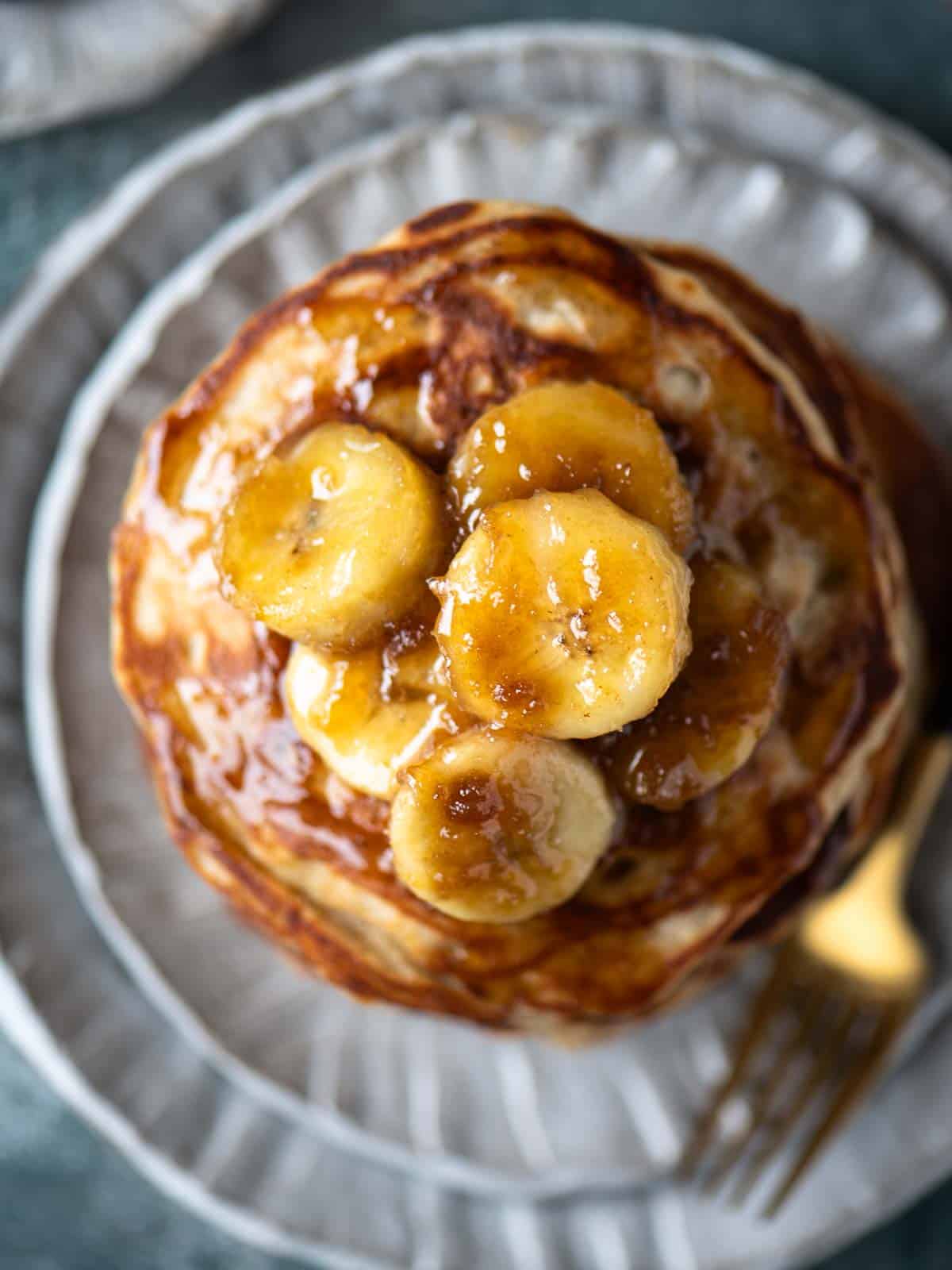 Overhead close-up of banana compote on top of a stack of pancakes.