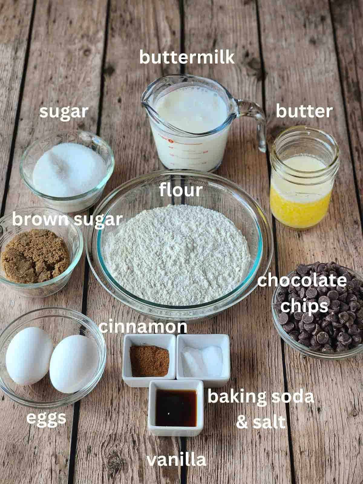 Labeled ingredients for a cake on a wood surface.