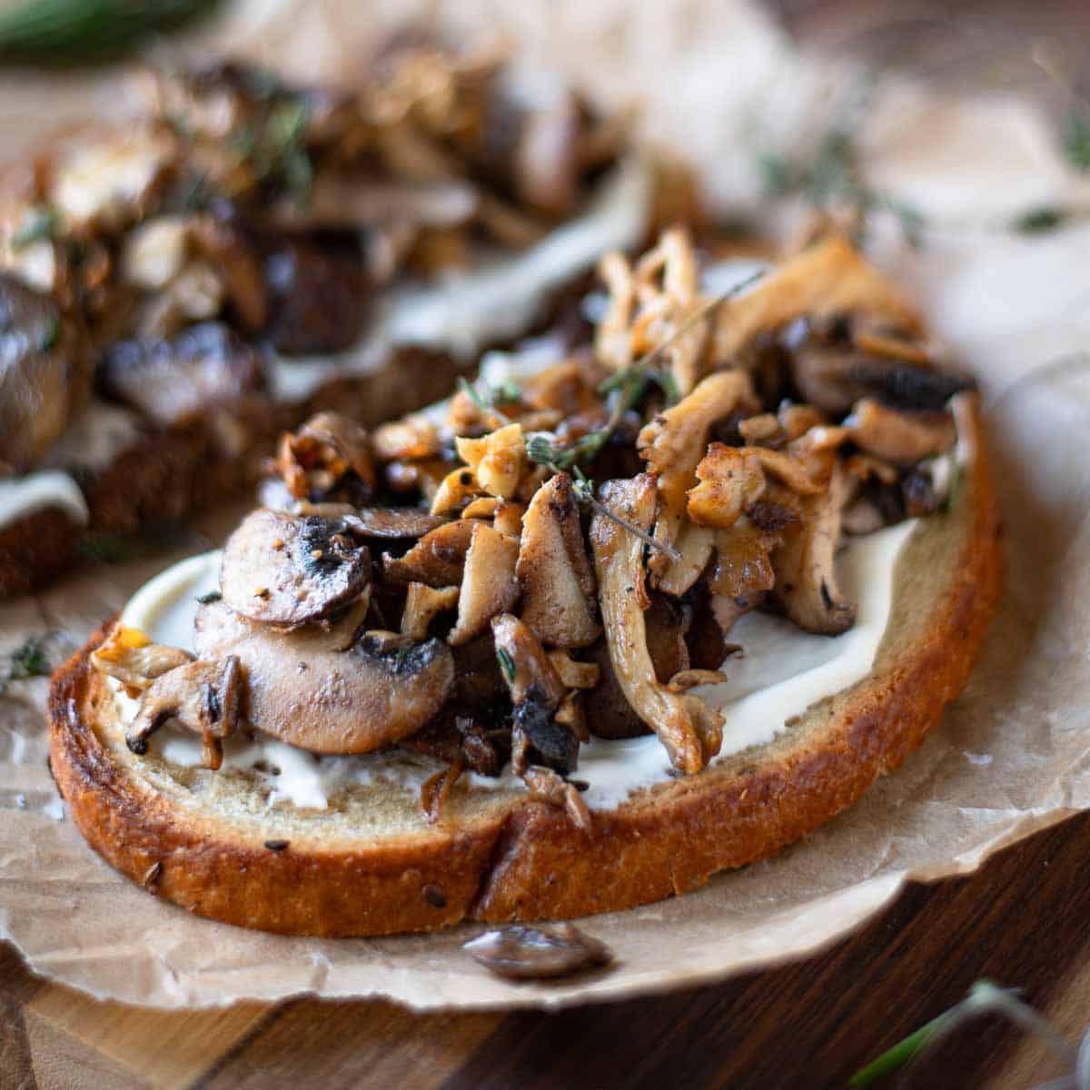 Mushrooms on toast on top of a wood surface.
