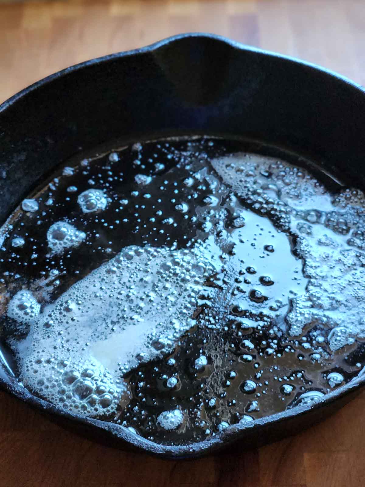 Melted butter in a black skillet.